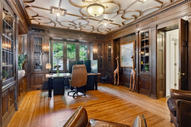 office area with ornamental molding, light hardwood / wood-style floors, and wood walls