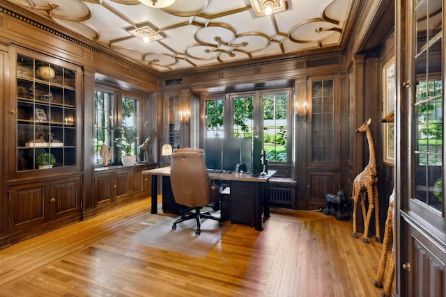 home office featuring crown molding, wooden walls, a healthy amount of sunlight, and light wood-style floors
