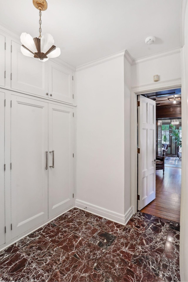 interior space with crown molding, marble finish floor, and baseboards