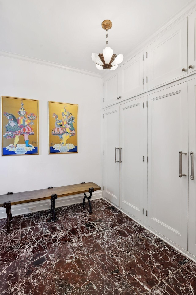 foyer featuring an inviting chandelier and crown molding