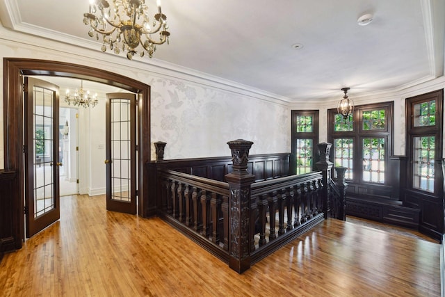 bedroom featuring ornamental molding, french doors, hardwood / wood-style flooring, and an inviting chandelier