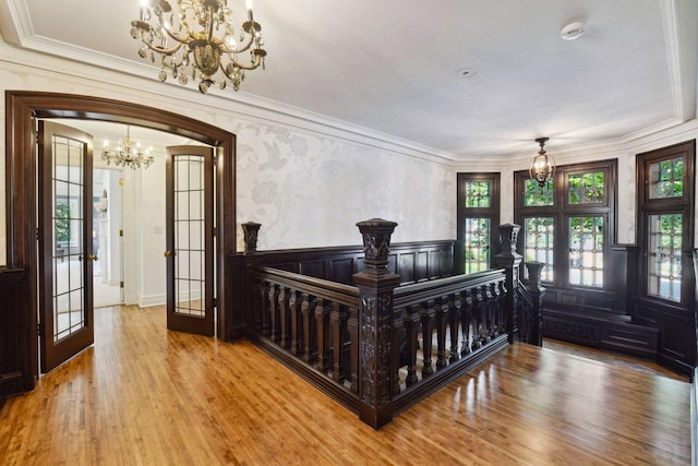 bedroom with crown molding, a notable chandelier, french doors, and wood finished floors