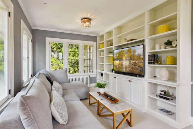 living room featuring radiator, crown molding, a wealth of natural light, and built in features