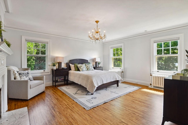 bedroom featuring a fireplace, ornamental molding, radiator, and a notable chandelier