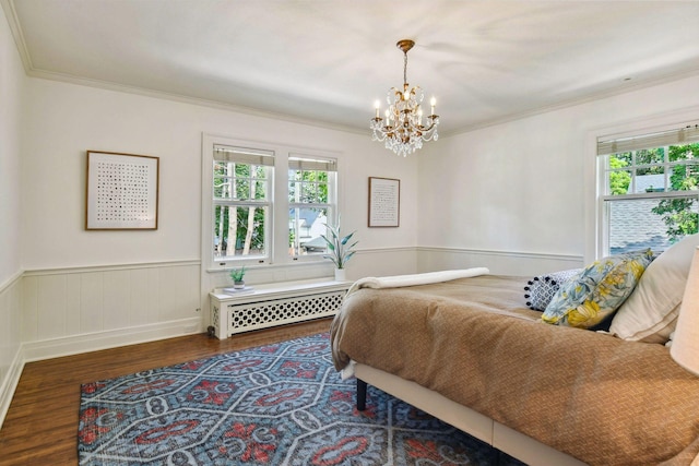 bedroom featuring multiple windows, ornamental molding, a chandelier, and wood finished floors