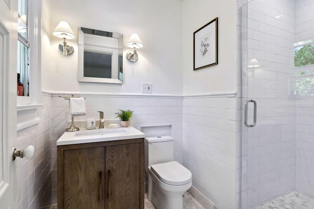 full bath featuring toilet, tile walls, wainscoting, and a stall shower