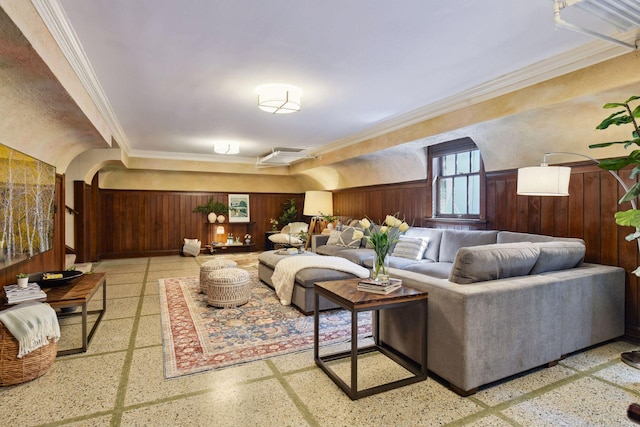 living room with crown molding and wooden walls