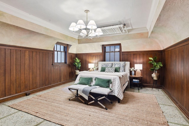 bedroom featuring ornamental molding, wainscoting, wooden walls, a chandelier, and speckled floor