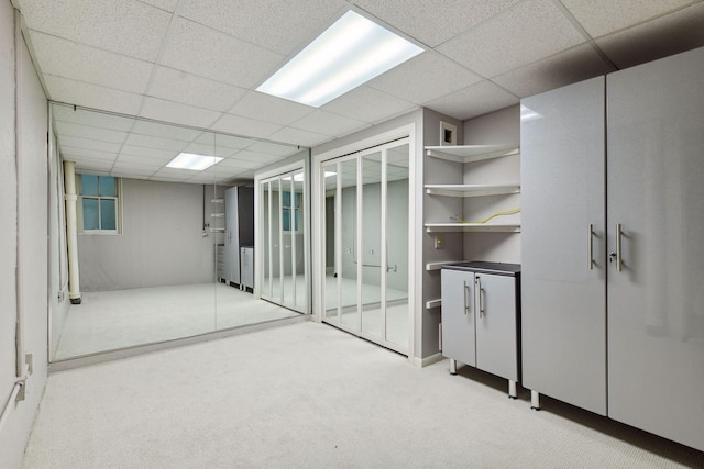 below grade area with carpet and a paneled ceiling