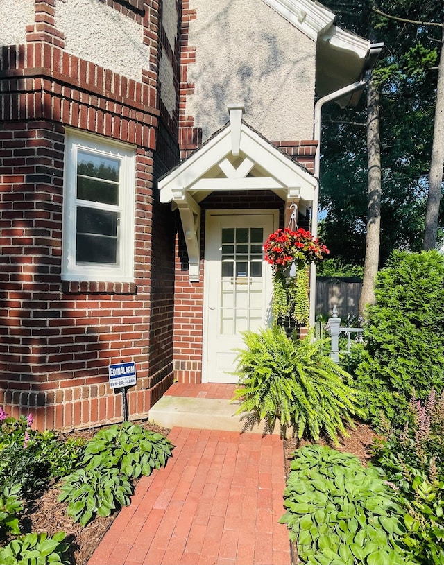 doorway to property featuring brick siding