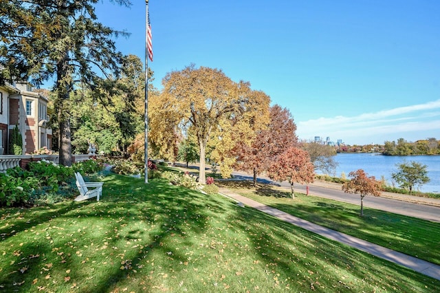 surrounding community featuring a water view and a lawn