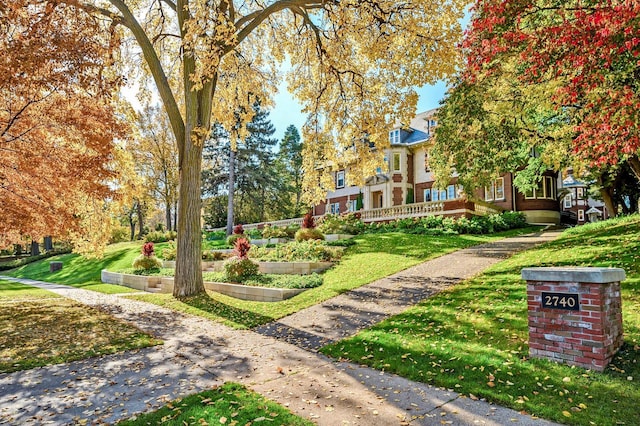 view of property's community with a yard and a garden
