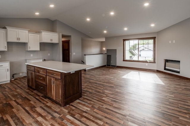 kitchen with a kitchen island, dark wood-type flooring, high vaulted ceiling, and white cabinetry