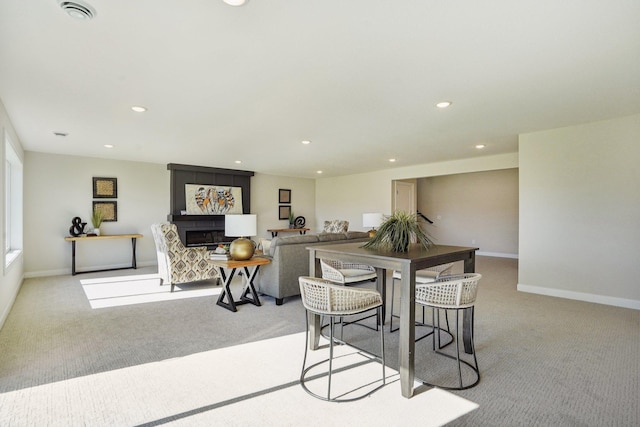 carpeted dining room with a fireplace