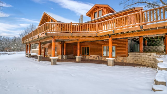 snow covered house with a wooden deck