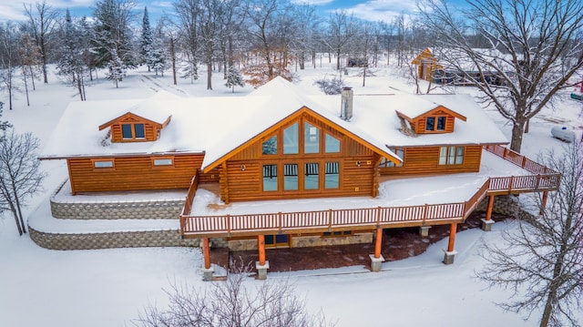28419 220th St, Shevlin, MN 56676 - snow covered rear of property with log exterior and a wooden deck