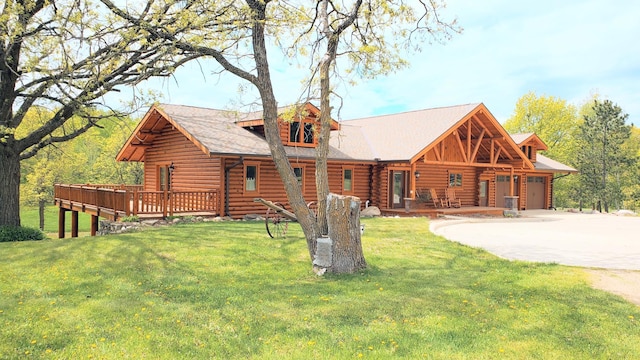 28419 220th St, Shevlin, MN 56676 - cabin featuring log siding, a front yard, an attached garage, driveway, and a deck