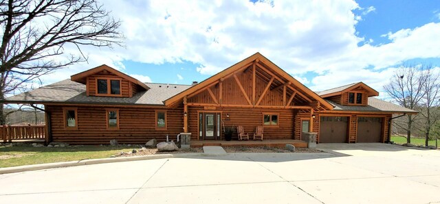 28419 220th St, Shevlin, MN 56676 - log home with log siding, concrete driveway, covered porch, an attached garage, and roof with shingles