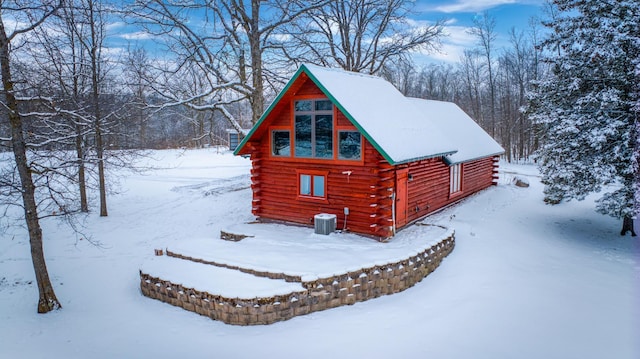 28419 220th St, Shevlin, MN 56676 - snow covered property featuring central AC unit, log siding, and an outdoor structure