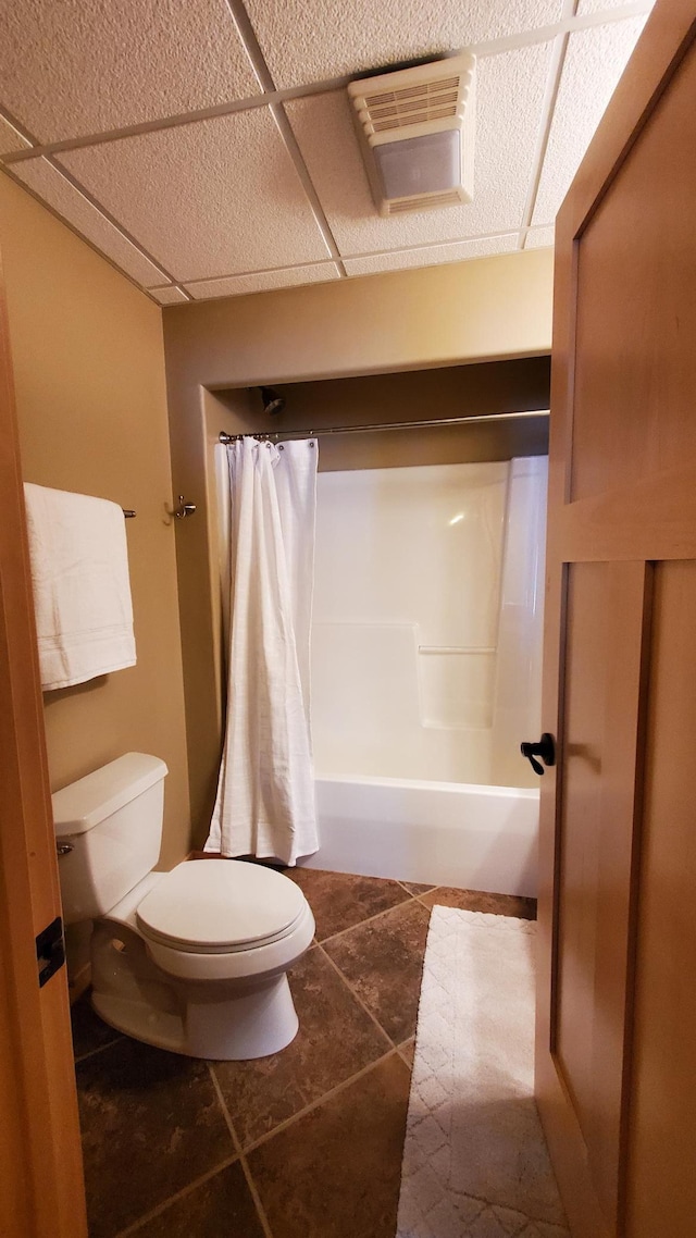28419 220th St, Shevlin, MN 56676 - bathroom featuring toilet, tile patterned flooring, shower / bathtub combination with curtain, and a drop ceiling
