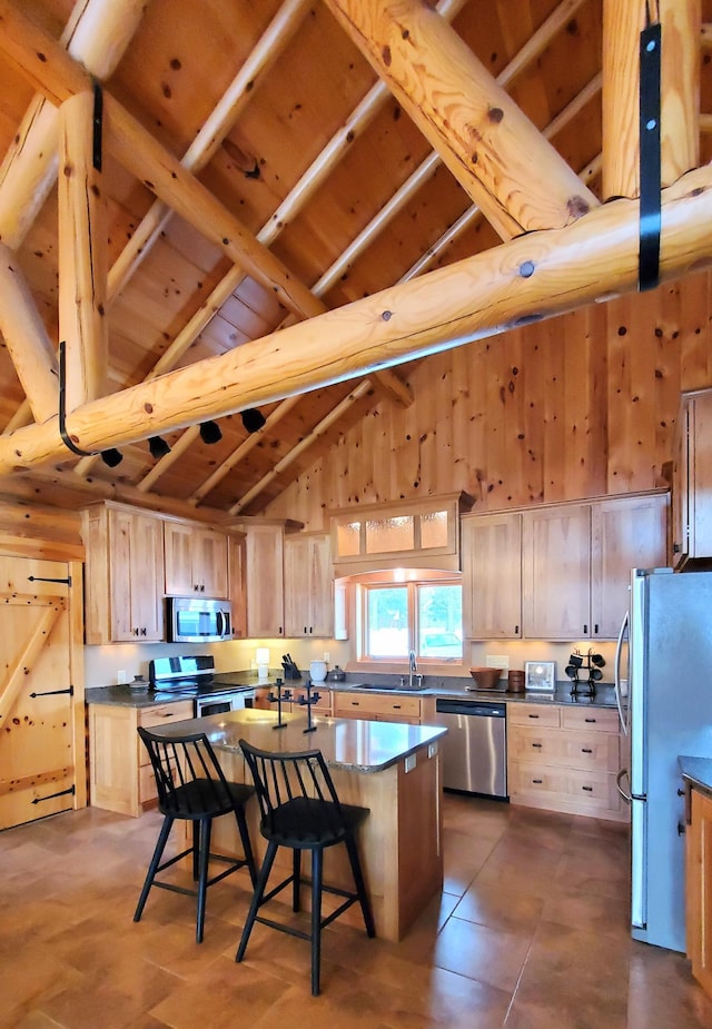 28419 220th St, Shevlin, MN 56676 - kitchen featuring appliances with stainless steel finishes, light brown cabinets, a kitchen bar, a sink, and a kitchen island