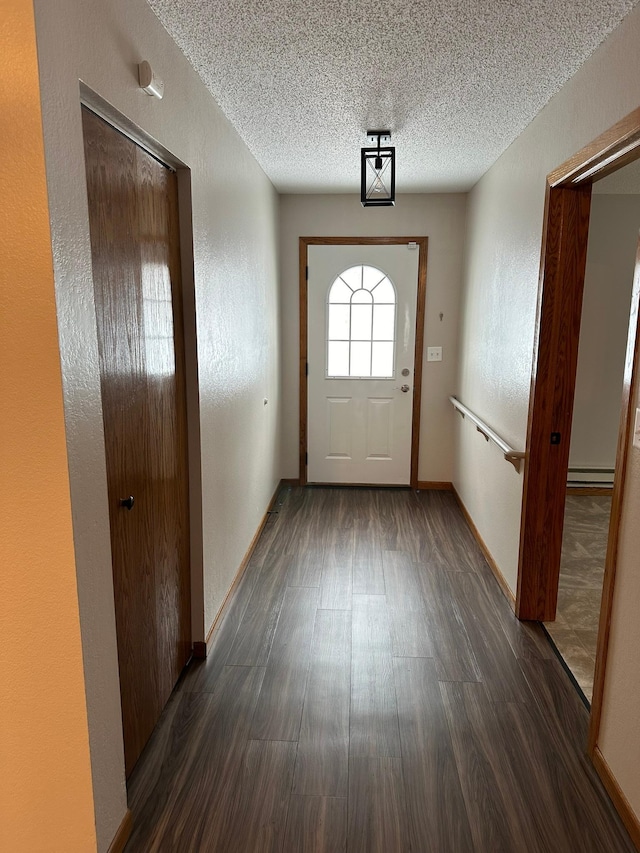 doorway featuring a textured ceiling, dark hardwood / wood-style flooring, and a baseboard heating unit