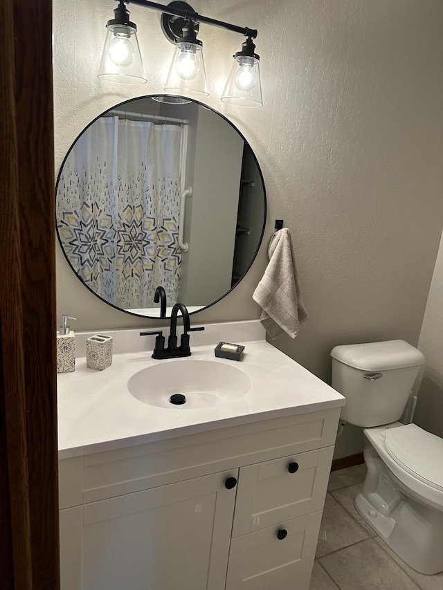 bathroom featuring tile patterned flooring, vanity, and toilet