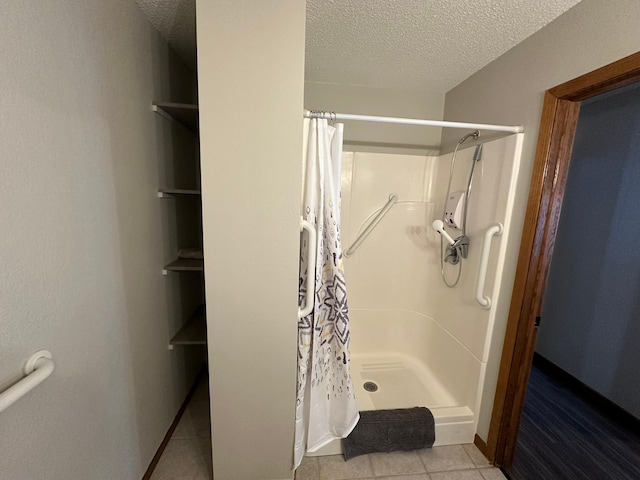 bathroom with tile patterned floors, a textured ceiling, and a shower with shower curtain