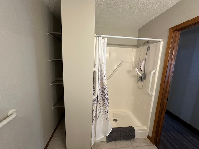 701 Ring Unit 7Th, Canby, MN 56220 - bathroom featuring baseboards, a textured ceiling, a shower stall, and tile patterned floors
