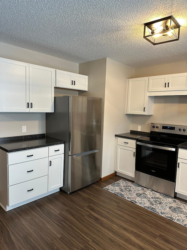 kitchen featuring a textured ceiling, stainless steel appliances, white cabinetry, and dark hardwood / wood-style floors