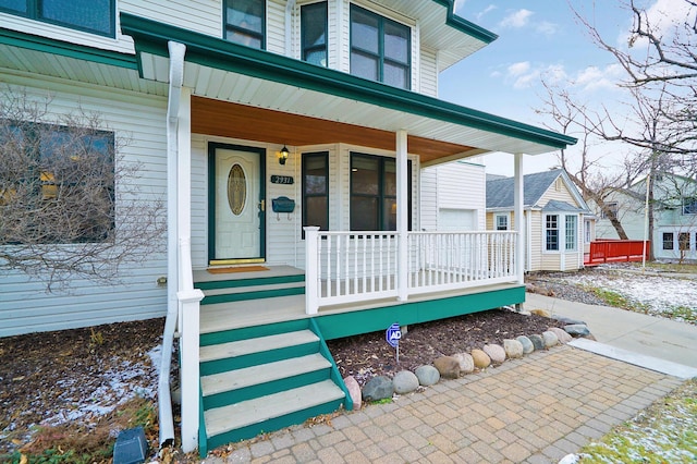 view of exterior entry featuring covered porch