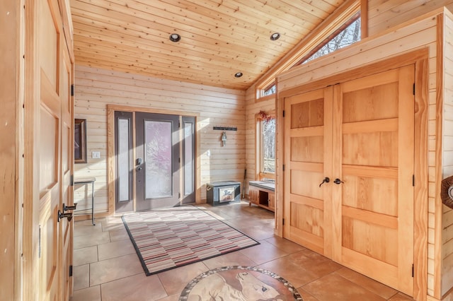 interior space featuring wooden ceiling, vaulted ceiling, and wooden walls