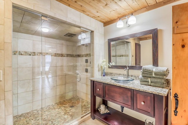 bathroom featuring a shower with shower door, wooden ceiling, and vanity