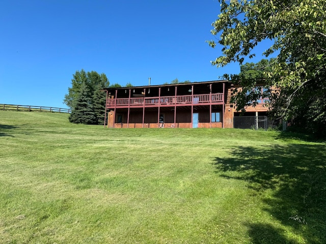 back of house featuring a wooden deck and a lawn