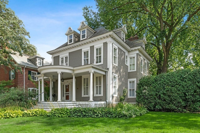 view of front of house with covered porch and a front lawn