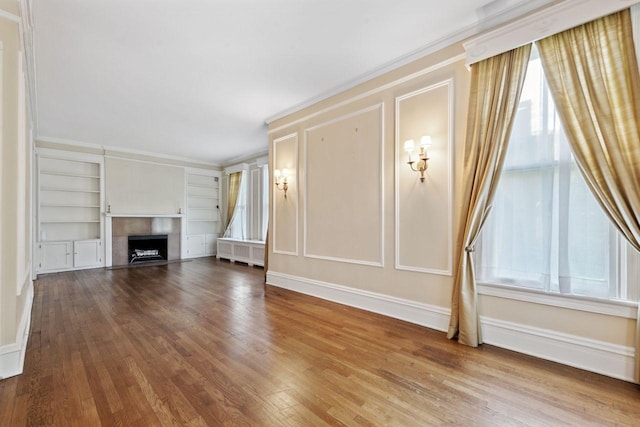 unfurnished living room featuring ornamental molding, hardwood / wood-style floors, and built in features