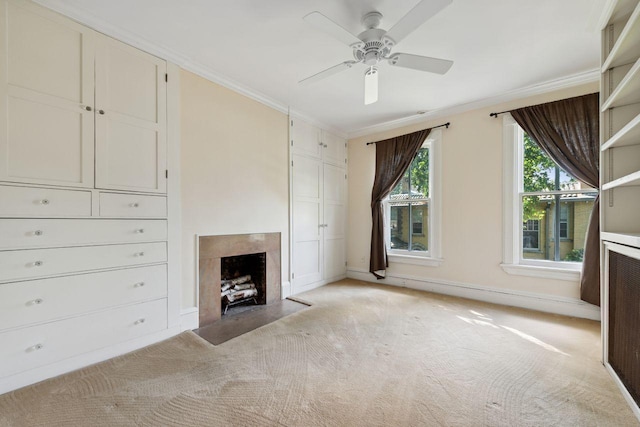 unfurnished living room featuring a fireplace, light carpet, ceiling fan, and crown molding