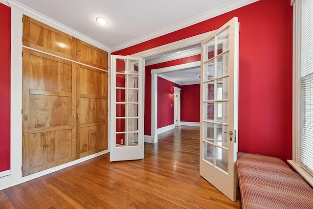 interior space with french doors, crown molding, and hardwood / wood-style floors