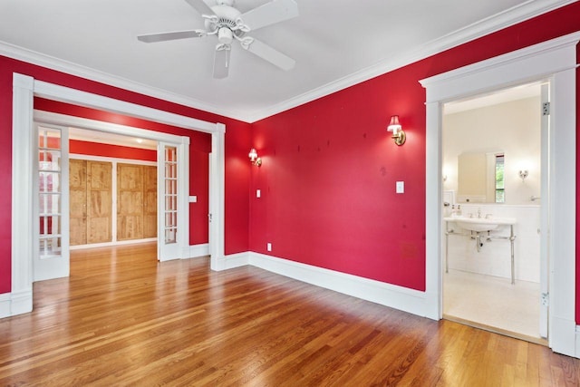 empty room with ceiling fan, hardwood / wood-style floors, and crown molding