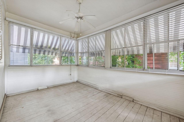 unfurnished sunroom featuring ceiling fan