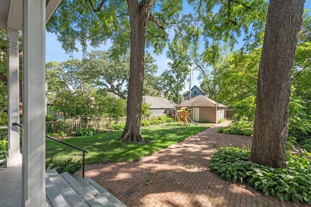 view of yard with an outbuilding, a playground, and a wooden deck