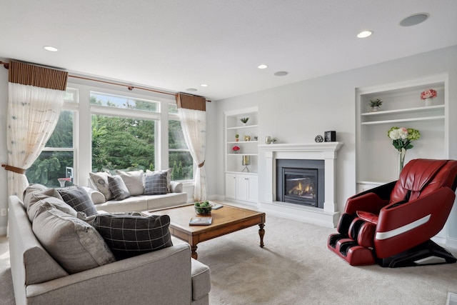 carpeted living room featuring recessed lighting, a glass covered fireplace, and built in features