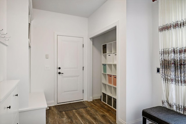 mudroom featuring dark wood finished floors and baseboards