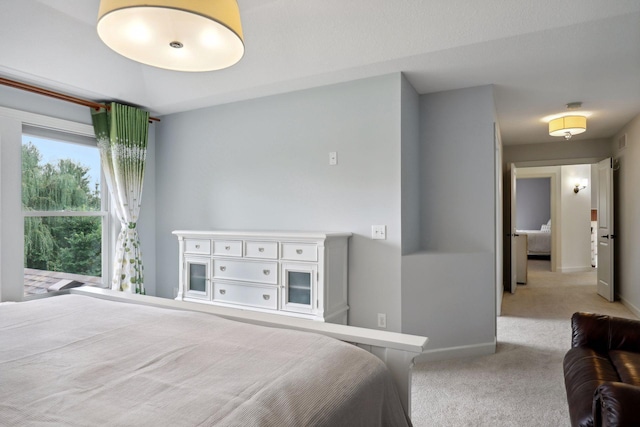 bedroom with baseboards and light colored carpet