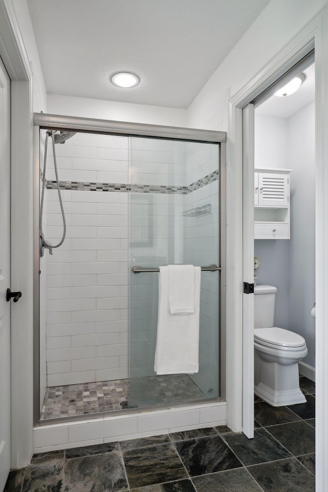 full bath with toilet and a stall shower