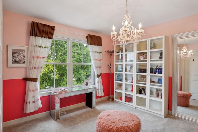 living area with a chandelier, carpet, and baseboards