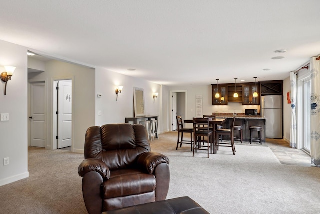 living area with baseboards and light colored carpet