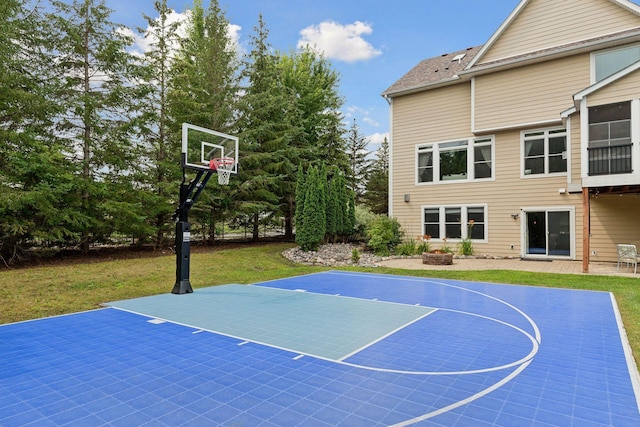 view of sport court with a lawn and basketball hoop