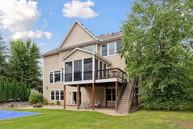 back of house with a lawn, an outdoor fire pit, a sunroom, a patio area, and stairs