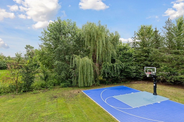 view of sport court featuring basketball hoop and a yard